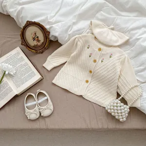 Detailansicht der Baby-Strickjacke mit Blumenstickerei und passender Baskenmütze