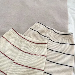 Détail du pantalon en tricot rayé pour bébé avec taille élastique en coton doux et confortable