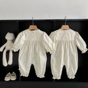 Close-up of floral baby romper featuring lace collar and elastic ruffled sleeve details
