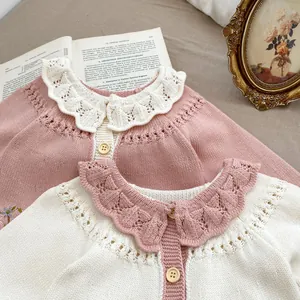 Details von Strickjacken mit hohlen Wellenkragen und Retro-Blumenstickerei-Textur