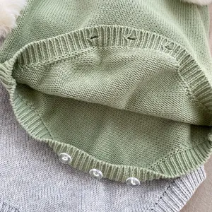 Dettaglio della tutina in maglia per neonati con trama a coste e tre bottoni trasparenti