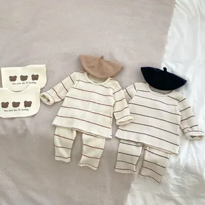 Vue à plat de pyjamas rayés pour bébé avec bonnets assortis et bavoirs ours mignons
