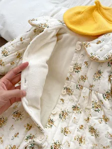 Detail of baby floral quilted romper with thick fleece lining and button closure