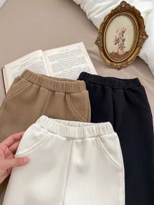 Detailed view of ribbed thermal flare pants for girls in brown, black, and beige colors