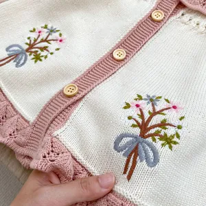 Detailansicht der Blumenstickerei und rosa Häkelkante an der Baby-Strickjacke