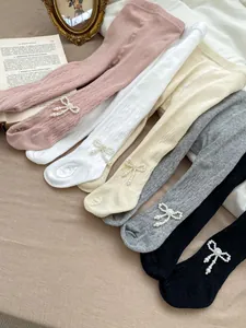 Detail der Strickstruktur und Perlenbogen an bunten Kinderstrumpfhosen aus Baumwolle