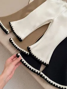 Detail of ribbed knit texture and decorative wavy crochet hem on girls flare leggings