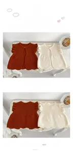 Detail of baby knitted vest with ruffle sleeves in caramel and off-white colors