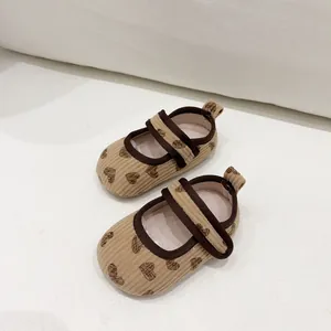 Detail of baby Mary Jane shoes with heart pattern, corduroy fabric and velcro strap