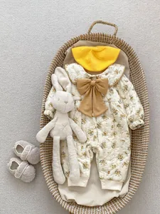 Detailed view of winter floral baby romper with a large yellow bow and knitted beret