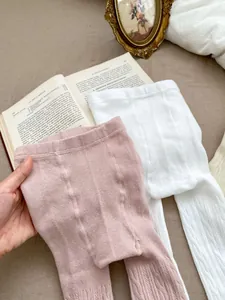 Detail der weichen Baumwollstrickstruktur und des hohen Bundes an rosa und weißen Babystrumpfhosen