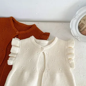 Detail of baby knitted vest featuring hollow heart pattern and ruffle fly sleeves