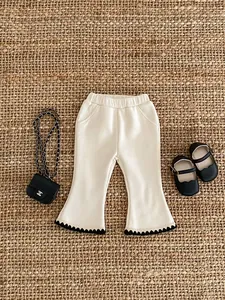 Macro detail of toddler ribbed flared trousers with contrast black serrated edge trim