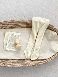 Detail von Strickstrumpfhosen für Mädchen mit Satinschleife und Perlenverzierung