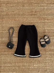 Detail view of girls flared fleece pants with white wavy hem and vertical ribbing texture