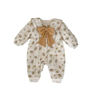 Winter floral baby romper with large bow and warm quilted fabric in cream yellow