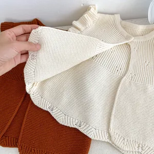 Detail of baby knit vest showing soft thick cotton texture and ruffled shoulder detail