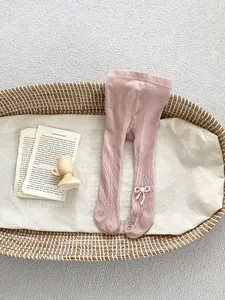 Detaillierte Strickstruktur der rosa Baby-Leggings mit elegantem Perlenbogen-Dekor