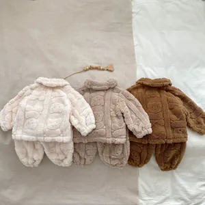 Détail de vêtements de nuit pelucheux pour bébé avec motifs d'ours en trois couleurs
