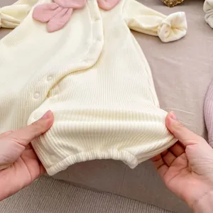 Détail de la texture en maille côtelée et boutons-pression latéraux du barboteuse bébé