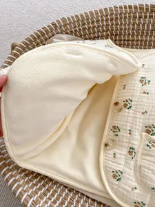 Detailansicht der Babyweste mit Blumenmuster, warmem Vliesfutter und Bernstein-Knöpfen