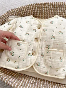 Detail der wattierten Baby-Blumenjacke mit drei Knöpfen und zwei kleinen Taschen