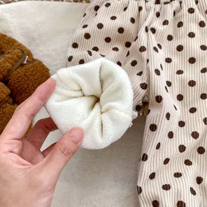 Fleece lined corduroy pants for kids featuring a brown polka dot pattern on cream base