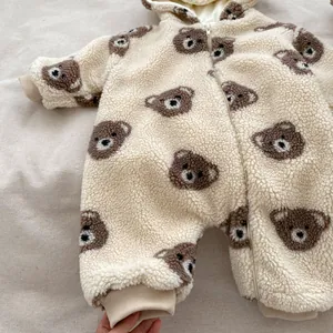 Macro shot of plush fleece infant romper featuring brown bear prints and smooth zipper closure