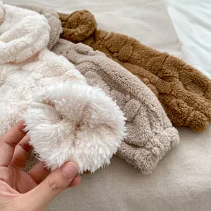 Détail de bandeaux en polaire pelucheuse avec texture torsadée en blanc, taupe et marron