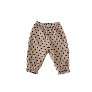 Beige corduroy pants for toddlers featuring brown polka dots and ruffled leg openings