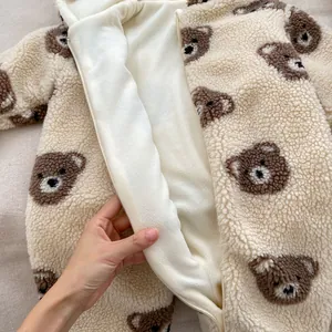 Detail of baby bear hooded romper showing soft lamb wool fleece lining and zipper