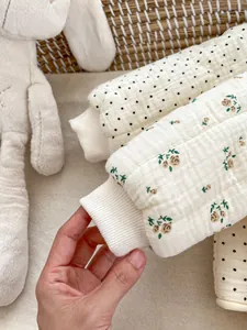Nahaufnahme der gesteppten Blumen-Babyjacke mit Rippbündchen und weicher Baumwollstruktur
