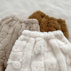 Détail du lot de shorts en peluche pour bébé en beige, kaki et marron foncé doux