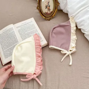 Détail de béguins d'hiver pour bébé avec bords à volants et lanières réglables