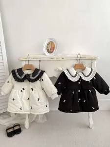 Detail of baby winter coat with lace collar, bow print, and ribbed cuffs for warmth