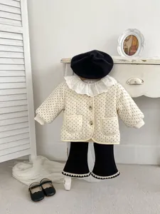 Detailansicht der gesteppten Blumenjacke mit Spitzenkragen und schwarzer Schlaghose