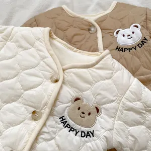 Detail of quilted baby jacket with bear embroidery and Happy Day text and buttons