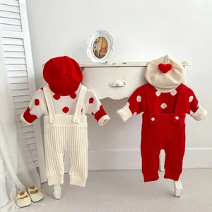 Détail d'un ensemble en tricot pour bébé avec pois et pantalon à bretelles côtelé