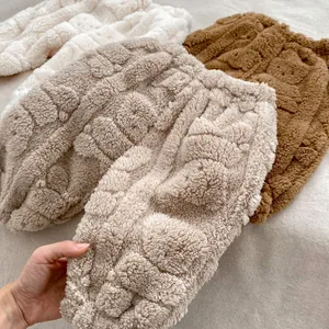 Détail d'un pantalon en peluche pour bébé en crème et marron avec texture gaufrée et polaire