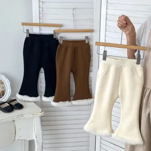 Detail of girls' flared trousers with fur trim and elastic waist in black, brown, and cream