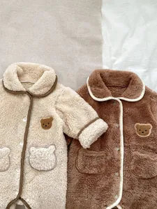 Dettaglio di pagliaccetti in pile per neonati con ricamo di orsacchiotto e tasche a orsetto