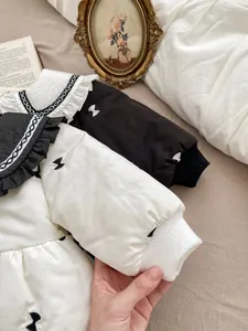 Detail of baby winter coat showing ruffled collar with embroidered bow patterns