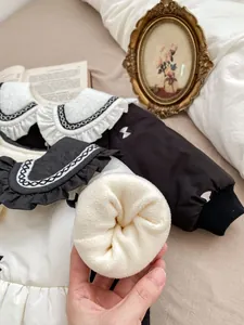 Detail showing plush sherpa lining and ruffled Peter Pan collar on winter baby coat