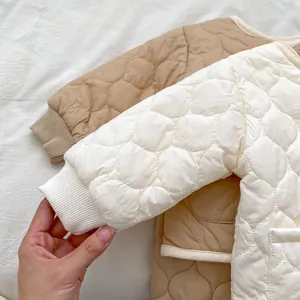 Detail of scalloped quilting and ribbed knit cuffs on infant winter puffer jacket