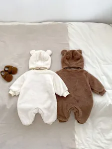 Detail of plush bear-eared baby rompers in cream and brown with thick fleece material