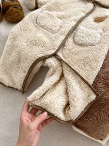 Dettaglio di una tutina neonato in pile pesante con orecchie da orso e scarpine morbide