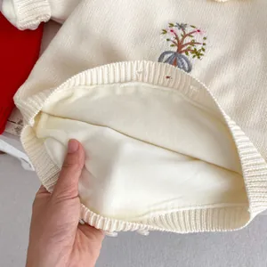 Détail de la barboteuse pour bébé montrant la doublure polaire et la broderie fleur