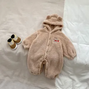 Close-up of soft beige fleece baby romper with cute bear ear hood and embroidery