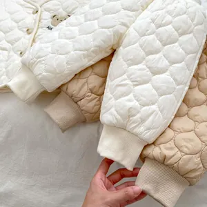 Detailed view of quilted cotton baby jackets with ribbed cuffs and bear embroidery