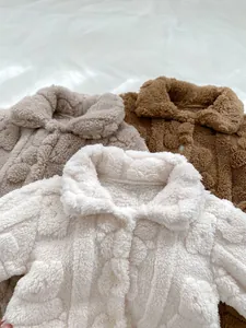 Detaillierte Nahaufnahme von weichem Sherpa-Fleece und Knöpfen an Baby-Overalls
